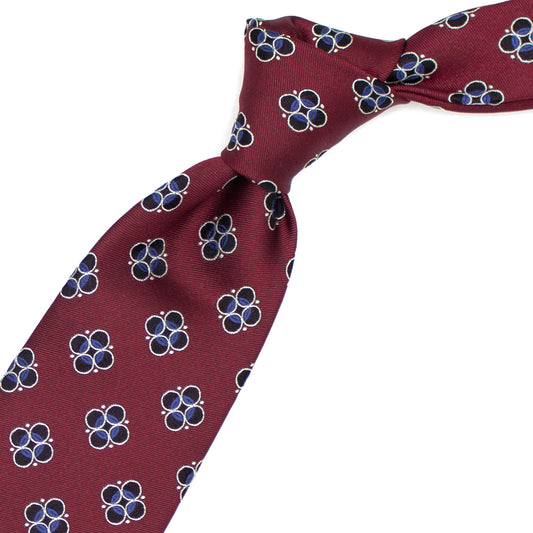 Red tie with blue, light blue and grey geometric pattern