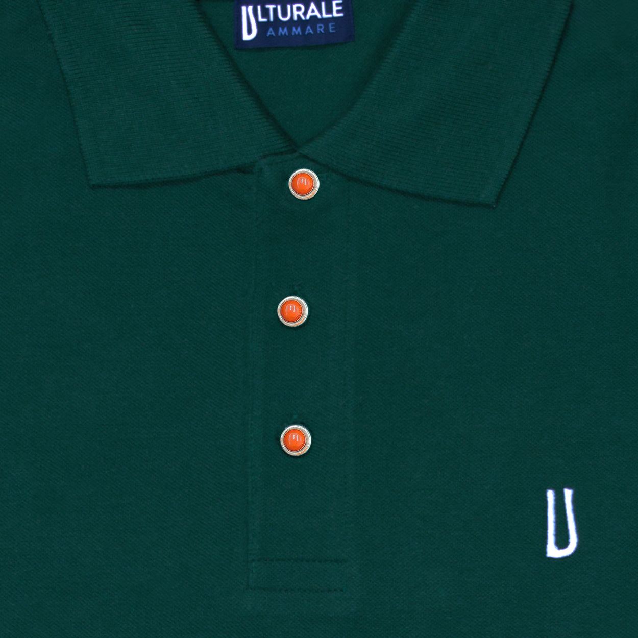 Green polo shirt with coral and silver buttons